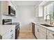 Modern kitchen with black appliances, white cabinets, and a sink at 2717 Hidden Lake Blvd # C, Sarasota, FL 34237