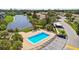 Aerial view of a community pool with lounge chairs and a lake provides a relaxing atmosphere at 2717 Hidden Lake Blvd # C, Sarasota, FL 34237