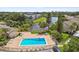 Aerial view of community swimming pool is surrounded by lounge chairs, tables, and beautiful foliage at 2717 Hidden Lake Blvd # C, Sarasota, FL 34237