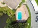 Aerial view of a community pool with lounge chairs, lush landscaping, and adjacent parking at 2717 Hidden Lake Blvd # C, Sarasota, FL 34237