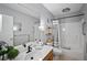 Clean bathroom with a large mirror, vanity, and shower-tub combination with grey and white accents at 380 Base E Ave # 202, Venice, FL 34285