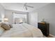 Cozy bedroom with a ceiling fan, natural light, and a dark dresser for ample storage at 380 Base E Ave # 202, Venice, FL 34285