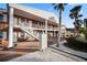 Two-story brick exterior featuring white trim and stairs, leading to charming unit entrances at 380 Base E Ave # 202, Venice, FL 34285