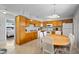 Eat-in kitchen features wood cabinets, white appliances, tile floor and eat-in wooden table at 380 Base E Ave # 202, Venice, FL 34285