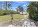 Expansive backyard with a storage shed, lush greenery, and stone pavers under a bright sky at 3816 N Cranberry Blvd, North Port, FL 34286