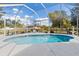 A sparkling blue swimming pool enclosed with a screened lanai is surrounded by a well-manicured lawn at 3816 N Cranberry Blvd, North Port, FL 34286