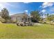 Backyard with a screened lanai, lush greenery, and mature trees on a sunny day at 3816 N Cranberry Blvd, North Port, FL 34286