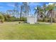 Well-maintained storage shed in a spacious, grassy yard with a bright blue sky backdrop at 3816 N Cranberry Blvd, North Port, FL 34286