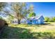 Spacious backyard showcasing the blue home and detached garage, surrounded by a well-maintained lawn at 434 W Grace St, Punta Gorda, FL 33950