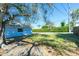 Large backyard featuring a mature tree offering shade, adjacent to the charming blue home at 434 W Grace St, Punta Gorda, FL 33950