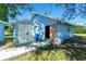 Charming blue outbuilding features an open door and convenient storage shed, set in a sunny outdoor space at 434 W Grace St, Punta Gorda, FL 33950