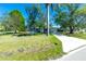 Charming front yard of a single-story blue home with a well-manicured lawn and mature trees at 434 W Grace St, Punta Gorda, FL 33950