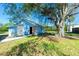 Charming blue shed nestled under a grand tree, set against a clear blue sky at 434 W Grace St, Punta Gorda, FL 33950
