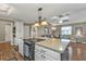 Granite island with cooktop in modern kitchen connects to an open living area at 5211 Prime Ter, North Port, FL 34286
