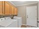 Bright laundry room features modern washer and dryer and storage cabinets at 5211 Prime Ter, North Port, FL 34286