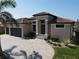 Stunning home featuring a three-car garage, lush landscaping, and a tile roof, perfect for luxurious living at 556 Monaco Dr, Punta Gorda, FL 33950
