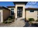 Inviting home entrance showcasing a tiled walkway, well-manicured landscaping, and a modern glass door at 556 Monaco Dr, Punta Gorda, FL 33950