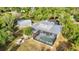 Aerial view showcases enclosed pool area, separate garage, and a large yard filled with trees at 5601 Taylor Rd, Punta Gorda, FL 33950