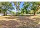 Vast backyard with mature trees, partially screened pool, and ample space for outdoor recreation and relaxation at 5601 Taylor Rd, Punta Gorda, FL 33950