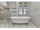 Bathroom featuring a freestanding tub, glass enclosed shower, and marble tile flooring at 5601 Taylor Rd, Punta Gorda, FL 33950