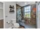 Modern bathroom featuring a tiled shower with glass door, floating shelves, and stylish fixtures at 5601 Taylor Rd, Punta Gorda, FL 33950