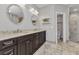 Bathroom featuring a granite counter, dark cabinets, dual mirrors, and a glass shower at 5601 Taylor Rd, Punta Gorda, FL 33950