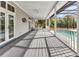 Spacious covered patio with ceiling fans, dining area, and a screened-in pool in the background at 5601 Taylor Rd, Punta Gorda, FL 33950