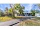 Charming two-story home with a welcoming front porch, surrounded by mature trees and a lush green lawn at 5601 Taylor Rd, Punta Gorda, FL 33950