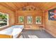 Cozy interior of the playhouse with wood-paneled walls, multiple windows, and comfortable furniture at 5601 Taylor Rd, Punta Gorda, FL 33950