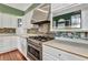 Well-equipped kitchen featuring stainless steel stove, custom backsplash, and modern microwave at 5601 Taylor Rd, Punta Gorda, FL 33950