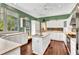Bright kitchen with white cabinetry, stainless steel appliances, island, and hardwood floors at 5601 Taylor Rd, Punta Gorda, FL 33950