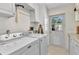 Laundry room with modern appliances, custom cabinets, and a door to the outside at 5601 Taylor Rd, Punta Gorda, FL 33950