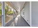 Long, screened-in porch with grey decking, railing, and natural light at 5601 Taylor Rd, Punta Gorda, FL 33950