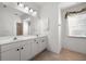 Bathroom featuring dual sinks, large mirror, and modern fixtures with a shower-tub combination at 6938 Rabbit Ave, North Port, FL 34291