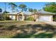 Inviting single-story home with a well-maintained front lawn and charming architectural details at 6938 Rabbit Ave, North Port, FL 34291