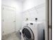 Well-lit laundry room with shelving and a modern washing machine for convenient home upkeep at 6938 Rabbit Ave, North Port, FL 34291