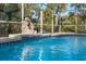 Sparkling pool with rock waterfall feature surrounded by lush greenery for ultimate relaxation at 6938 Rabbit Ave, North Port, FL 34291