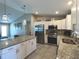 Spacious kitchen featuring stainless steel appliances, granite countertops, and ample white cabinetry at 7243 Patricia Pl, Englewood, FL 34224