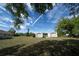 Expansive backyard featuring storage sheds, mature trees, and lush greenery at 825 Robinhood Dr, Punta Gorda, FL 33982