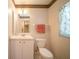 Bathroom featuring a vanity sink, toilet, decorative border, and window at 825 Robinhood Dr, Punta Gorda, FL 33982