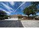 Inviting one-story home featuring a wide driveway, attached two-car garage, and a charming wooden deck area at 825 Robinhood Dr, Punta Gorda, FL 33982
