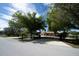 Peaceful suburban street view featuring a well-maintained home with mature trees and landscaping at 825 Robinhood Dr, Punta Gorda, FL 33982