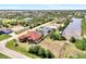 Panoramic aerial view of a home situated near a canal, surrounded by palm trees and greenery at 10393 Harlingen St, Port Charlotte, FL 33981