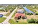 Expansive aerial view of a home with a red roof and a canal in the background at 10393 Harlingen St, Port Charlotte, FL 33981