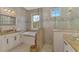 Elegant bathroom with a soaking tub, glass shower, double vanity, and neutral tile at 10393 Harlingen St, Port Charlotte, FL 33981