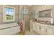 Elegant bathroom features a soaking tub, glass shower, granite vanity, and neutral tile at 10393 Harlingen St, Port Charlotte, FL 33981