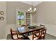 Bright dining room with a traditional wooden table and chairs, complemented by natural light from the large window at 10393 Harlingen St, Port Charlotte, FL 33981