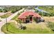 Aerial of home on a large lot with manicured lawn and red-tile roof near a waterway at 10393 Harlingen St, Port Charlotte, FL 33981