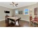 Spacious game room with a pool table, ceiling fan, and hardwood floors that offer entertainment and relaxation at 10393 Harlingen St, Port Charlotte, FL 33981