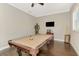 Spacious game room with a pool table, dark hardwood floors, a mounted TV, and white molding at 10393 Harlingen St, Port Charlotte, FL 33981